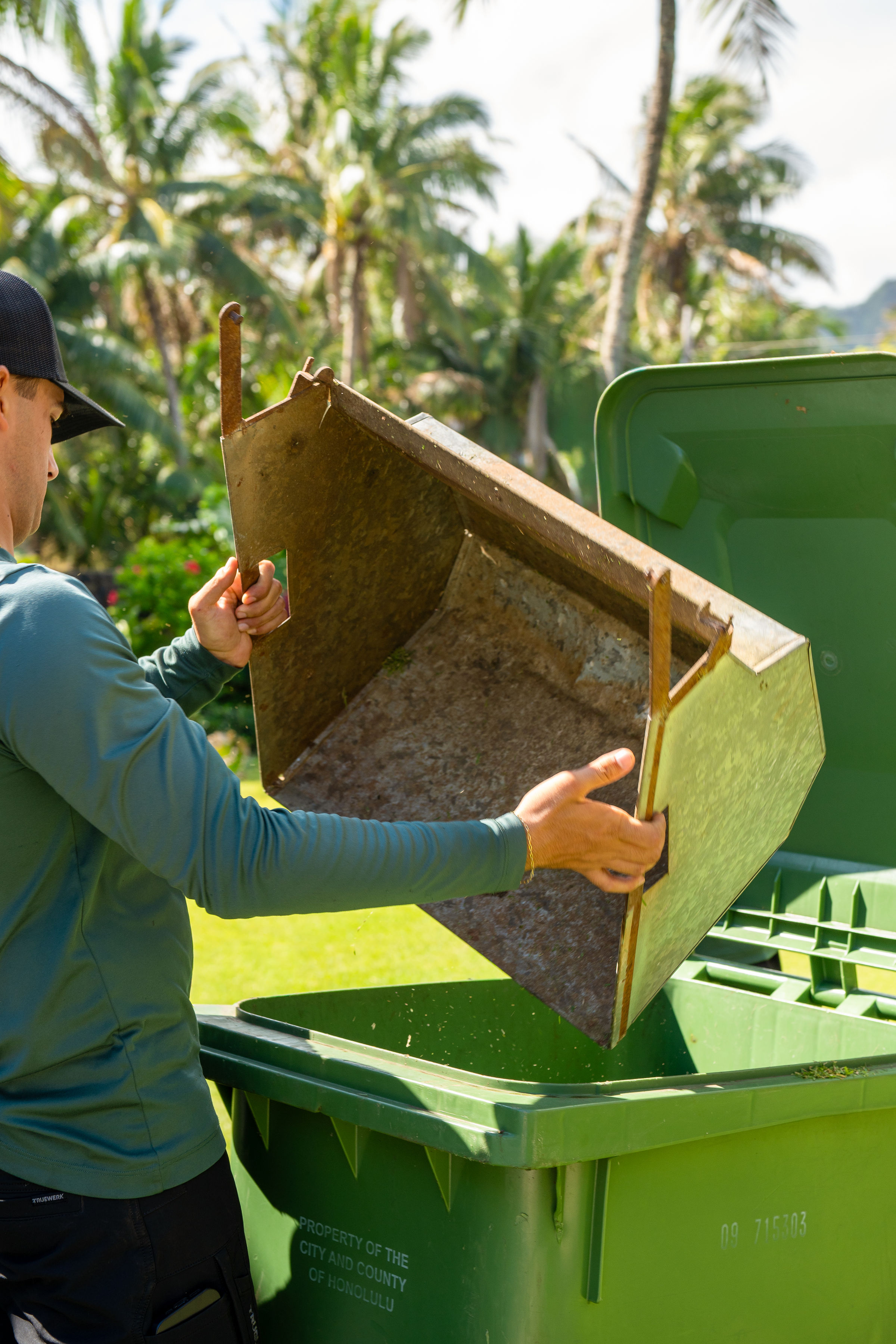 Island Scape technician emptying grass clippings for green waste removal